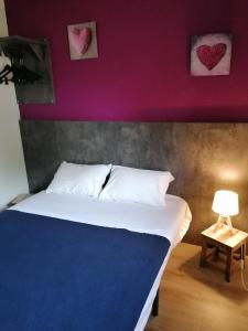 a bedroom with a bed with hearts on the wall at Cit'Hotel Saxotel Chalon-sur-Saône Nord in Champforgeuil