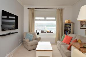 a living room with a couch and chairs and a window at Bute View in Kames