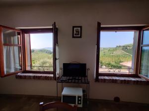 Habitación con 2 ventanas y ordenador en una mesa. en Agriturismo Rio Sordo en Barbaresco