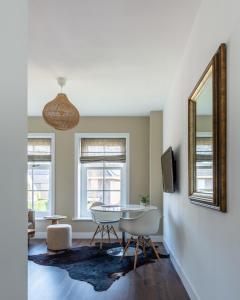 een woonkamer met een tafel en stoelen en een spiegel bij Studio in Boutique-Style - Cozy studio in Boheme-style in Alkmaar