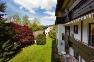 a view from the balcony of a house with a yard at Hotel Petra in Baiersbronn