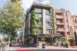 a building with ivy on the side of it on a street at Green Hotel in Genk