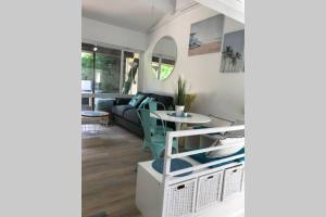 ein Wohnzimmer mit einem Sofa und einem Tisch in der Unterkunft Maison à 300m de la plage, quartier calme in Mimizan