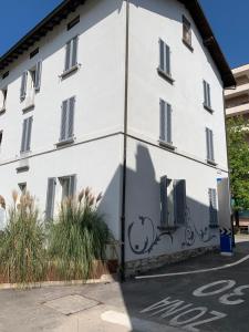a white building with a bicycle painted on the side at Smart Living Swiss in Chiasso