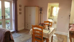a dining room with a table and chairs and a bedroom at Stag Cottage in Ilkeston