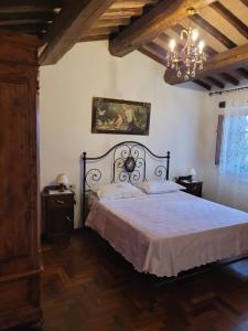 sypialnia z łóżkiem i żyrandolem w obiekcie Agriturismo "Apparitoio" w mieście Montelaterone