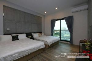a bedroom with two beds and a large window at 蘭陽河畔居二館 in Yilan City