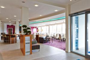 a lobby with a restaurant with tables and chairs at Holiday Inn Express Tamworth by IHG in Tamworth