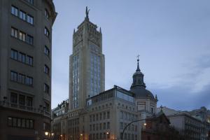 un grupo de edificios en una ciudad al atardecer en Petit Palace Alcalá, en Madrid