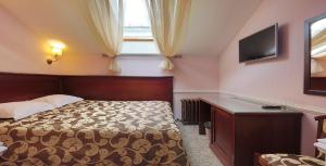 um quarto com uma cama, uma televisão e uma janela em Hotel Old City by Home Hotel em Moscovo