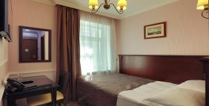 um quarto com uma cama, uma secretária e uma janela em Hotel Old City by Home Hotel em Moscovo
