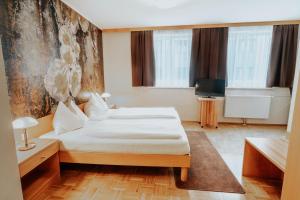 A bed or beds in a room at Hotel am Kapuzinerplatz