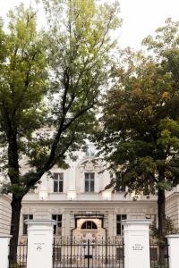 uma casa branca com árvores em frente em Zola Hotel - Palais de Bohème Adults Only em Viena