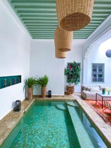 a swimming pool in the middle of a living room with a ceiling at Riad Danka in Marrakesh