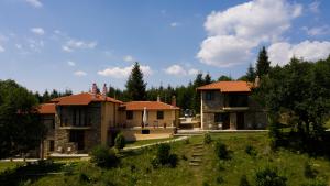 a couple of houses in a field with trees at Guesthouse Rodamos in Taxiarchis