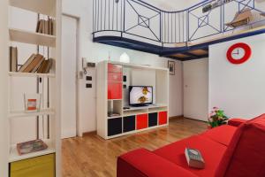 ローマにあるVatican Holiday Homeのリビングルーム(赤いソファ、テレビ付)