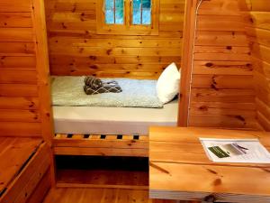 a dog laying on a bed in a wooden cabin at Pods Alte Schule in Elchweiler