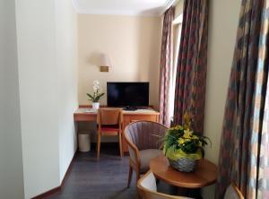 a room with a desk and a chair and a television at Albergo Faido in Faido