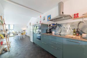 une cuisine avec des placards bleus et un comptoir dans l'établissement le Gabut vue port, à La Rochelle