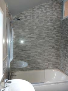 a bathroom with a bath tub and a sink at Lovely 2 bedroomed flat in the centre of Longton in Longton