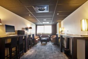 une chambre d'hôtel avec un bar avec des chaises et une salle d'attente dans l'établissement Appart'City Confort Marseille Centre Prado Vélodrome, à Marseille