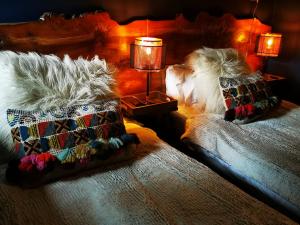 1 dormitorio con 2 camas con almohadas y lámpara en Drumdelgie Cottages, en Huntly