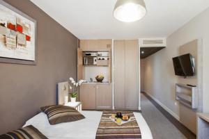 a hotel room with a bed and a tv at Appart'City Confort Marseille Centre Prado Vélodrome in Marseille