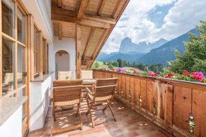 a balcony with a table and chairs and mountains at Apt Lara Ruveda in Ortisei
