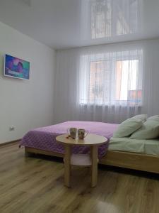 Un dormitorio con una cama y una mesa con dos tazas. en Яровиця з Кондиціонером,Центр, en Lutsk