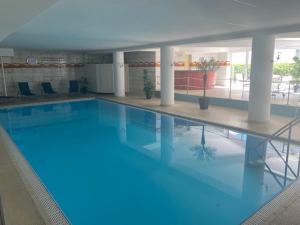 a large blue swimming pool in a building at Penthouse - Sunset Dream in Uhldingen-Mühlhofen