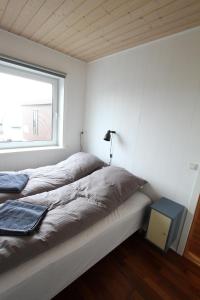 Schlafzimmer mit einem Bett und einem Fenster in der Unterkunft Modern apartment near beach, marina & city centre in Tórshavn