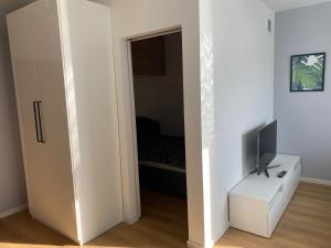 a white room with a television and a white cabinet at Apartament Bajka in Bydgoszcz