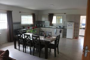 cocina con mesa y sillas y cocina con nevera en Dubbel woonhuis Selderiestraat Paramaribo, en Paramaribo