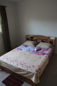 Un dormitorio con una cama con una manta floral. en Dubbel woonhuis Selderiestraat Paramaribo, en Paramaribo