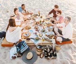 a group of people sitting around a table on the beach at Panorama Hotel - Free EV Charging Station in Varna City