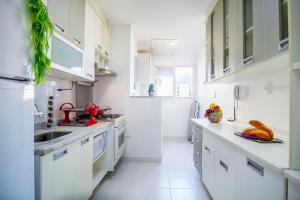 a white kitchen with white counters and white cabinets at 3 Quartos, espaçoso, Shopping Raposo in Sao Paulo