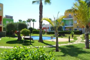 park z palmami i basenem w obiekcie Apartamento Pueblo Cid w mieście El Verger