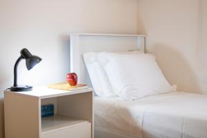 a bed with white sheets and an apple on a night stand at 3 Quartos, espaçoso, Shopping Raposo in Sao Paulo