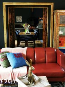 ein Wohnzimmer mit einem roten Sofa und einem Tisch in der Unterkunft Drumdelgie Cottages in Huntly