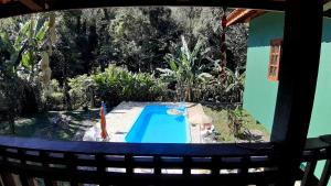 a view of a swimming pool in a yard at Chalé Vagalume Boiçucanga in Boicucanga +19 photos