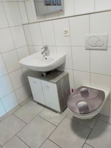 uma casa de banho com um lavatório e um WC em Studio Seeblick em Rheineck