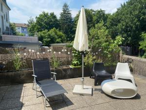 a patio with chairs and an umbrella and a table at Joline private guest apartment feel like home in Nidau