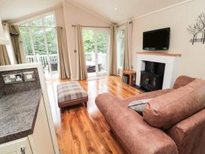 a living room with a couch and a fireplace at Number 43 Burnside Lodge in Morpeth
