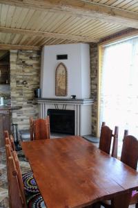 ein Esszimmer mit einem Holztisch und einem Kamin in der Unterkunft Cottage "Karpatske Shale" in Jaremtsche