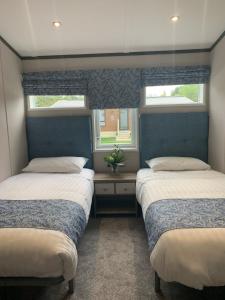 Barmby on the MoorにあるGraceland Lodge with Hot Tubの窓が2つある部屋にベッドが2つある