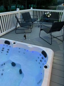 a hot tub on a deck with chairs and a table at Graceland Lodge with Hot Tub in Barmby on the Moor