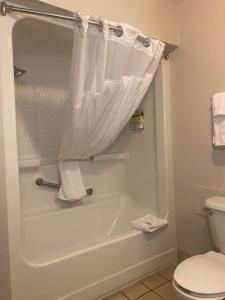 ein Badezimmer mit einer weißen Badewanne und einem WC in der Unterkunft Holiday Inn Express Hotel & Suites Hinesville, an IHG Hotel in Hinesville