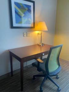 Cette chambre comprend un bureau avec une chaise et une lampe. dans l'établissement Holiday Inn Express Hotel & Suites Hinesville, an IHG Hotel, à Hinesville
