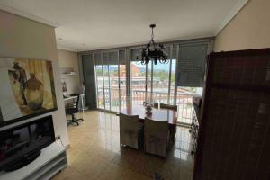 eine Küche mit einem Tisch und Stühlen sowie einem großen Fenster in der Unterkunft Appartement "Los Pinos" vue sur mer imprenable in Grao de Castellón