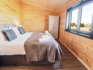 Postel nebo postele na pokoji v ubytování Bacheiddon Log Cabin